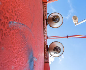Low angle view of electric lamp against wall