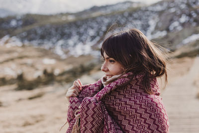 Side view of woman wrapped in shawl