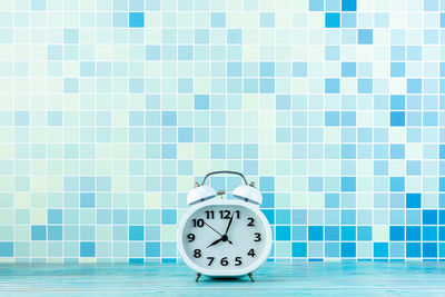 Close-up of clock on tiled floor