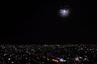Illuminated cityscape against sky at night