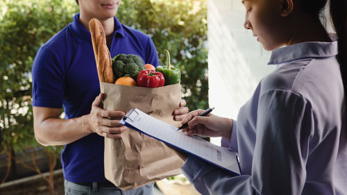 Rear view of man and woman standing on cutting board