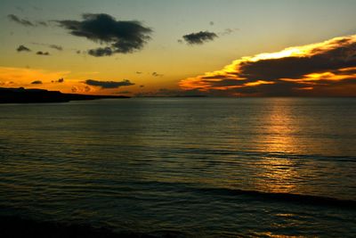 Scenic view of sea against dramatic sky during sunset