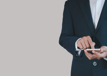 Midsection of businessman gesturing against white background