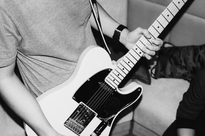 Midsection of man playing guitar