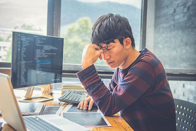 Stressed businessman sitting at desk in office