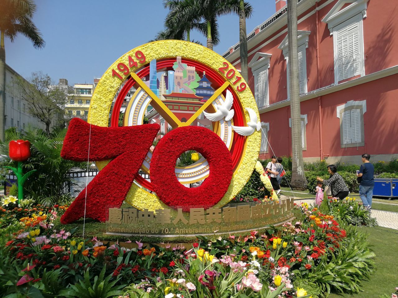 RED FLOWERING PLANTS BY BUILDING