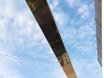 Low angle view of bridge against cloudy sky