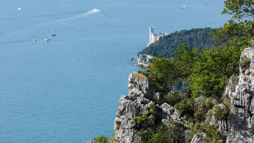 High angle view of sea by mountain against sky