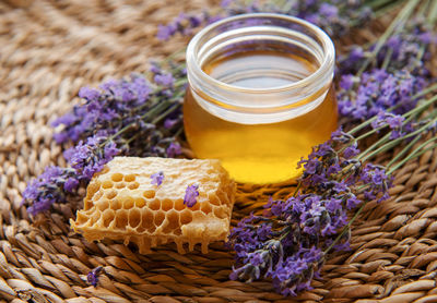 Glass of honey, honeycomb and lavender flowers