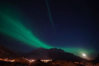 Low angle view of illuminated mountain against sky at night