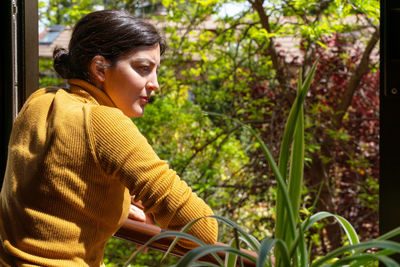 Thoughtful woman looking through window