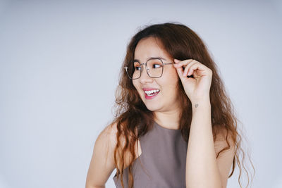 Portrait of a smiling young woman against white background