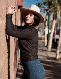 Portrait of young woman wearing hat standing outdoors