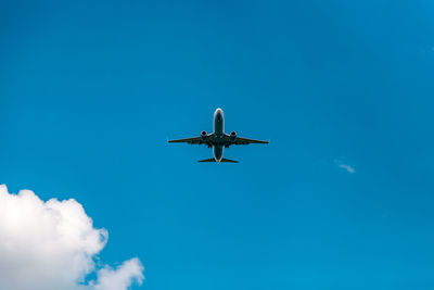 Low angle view of airplane against blue sky