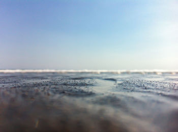 Surface level of beach against clear sky