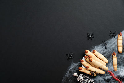 Close-up of man holding hands against black background