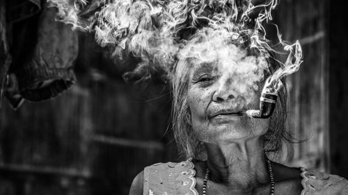 Portrait of senior woman smoking pipe