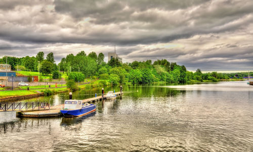 Boats moored in river against sky