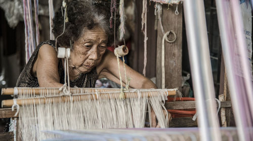 Senior woman working on machinery in textile industry