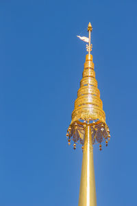 Low angle view of illuminated tower against blue sky