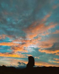 Silhouette woman against sky during sunset