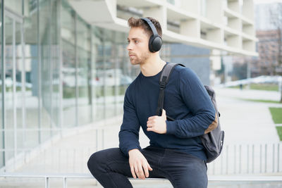 Young man with headphones on city street