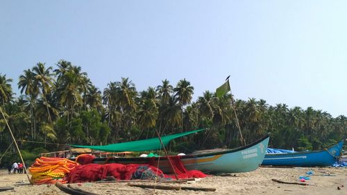 Boats on beach against clear blue sky