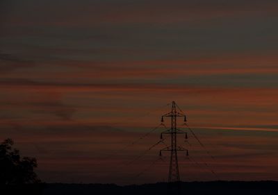 Silhouette electricity pylon against sky during sunset