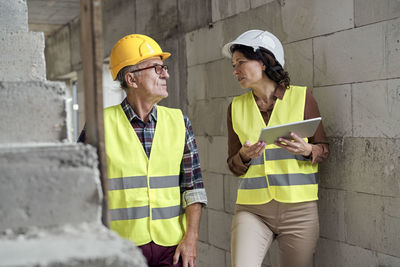 Colleague discussing with architect at construction site