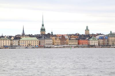 River by buildings against sky in city