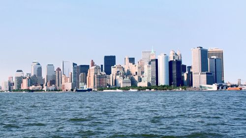 City at waterfront against clear sky