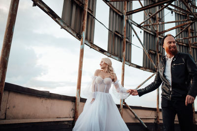 Couple holding hands while standing against wall