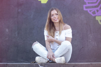 Portrait of a smiling young woman sitting outdoors