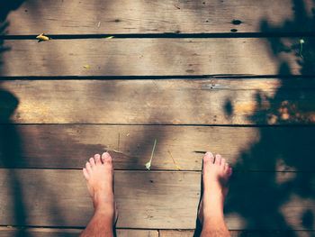 Low section of man standing on hardwood floor