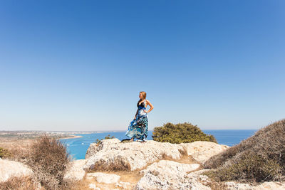 Man standing by sea against clear blue sky
