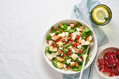 Fruits salad with nuts, balanced food, clean eating. spinach with apples, pecans 