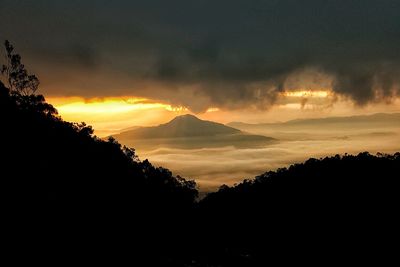 Scenic view of silhouette mountains against sky at sunset