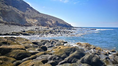 Scenic view of rocks on beach against sky