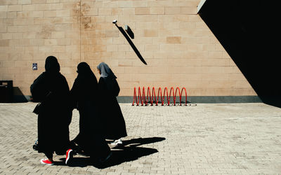 Rear view of people walking at beach