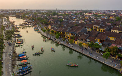 High angle view of boats in river amidst buildings in city