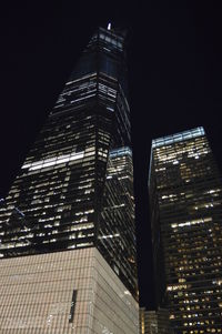 Low angle view of illuminated buildings against sky at night