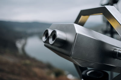 Coin operated binoculars against blurred landscape