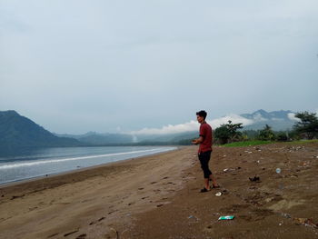 Full length of man on beach against sky