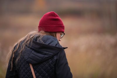 Woman wearing hat standing against snow during winter