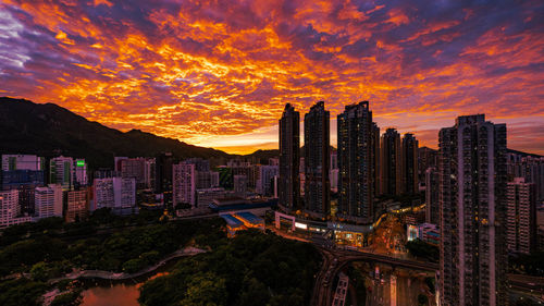 Buildings in city against sky during sunset