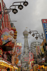 Low angle view of ferris wheel against buildings in city