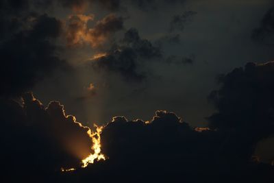 Low angle view of silhouette trees against cloudy sky