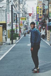 Full length portrait of smiling standing on road in city