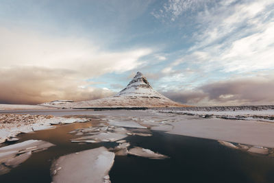 View of frozen lake against cloudy sky