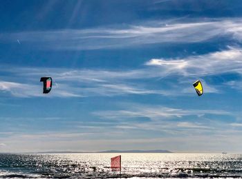 People paragliding over sea against sky